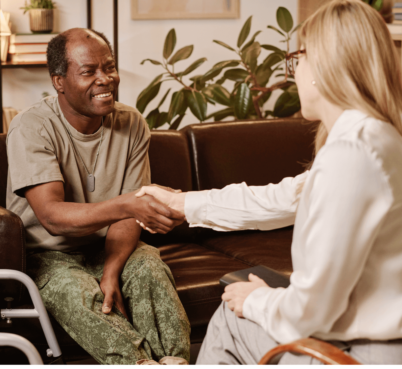 Older man and woman shaking hands, smiling.
