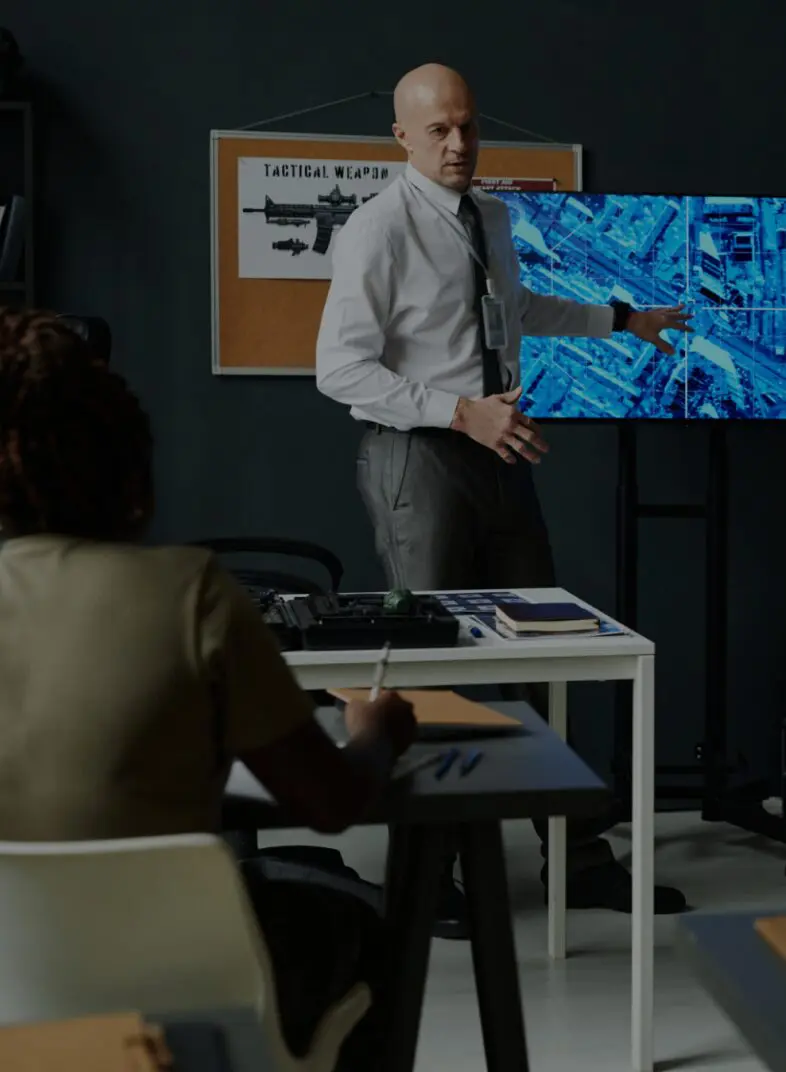 Man presenting data on screen to group.